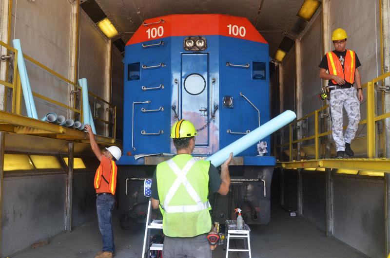 Vinyl rolls are organized and placed on their respective sides of the locomotive.
